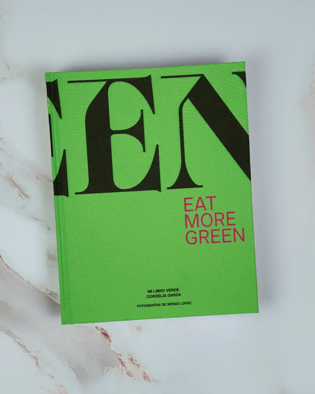 Libro Green con tipografía verde fluorescente sobre fondo de mármol claro.